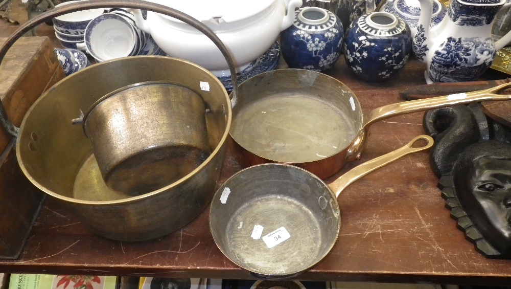 A copper frying pan with brass handle stamped `Helvetia`, another similar and two brass jam pans