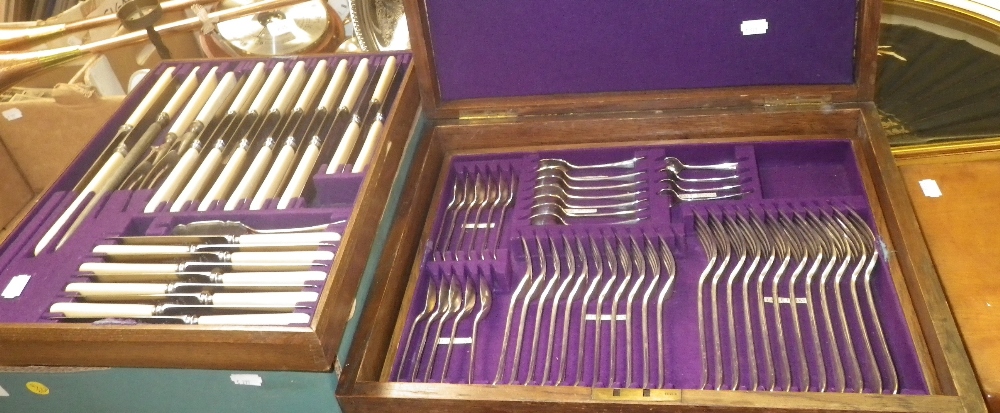 An oak canteen containing a large quantity of assorted plated cutlery