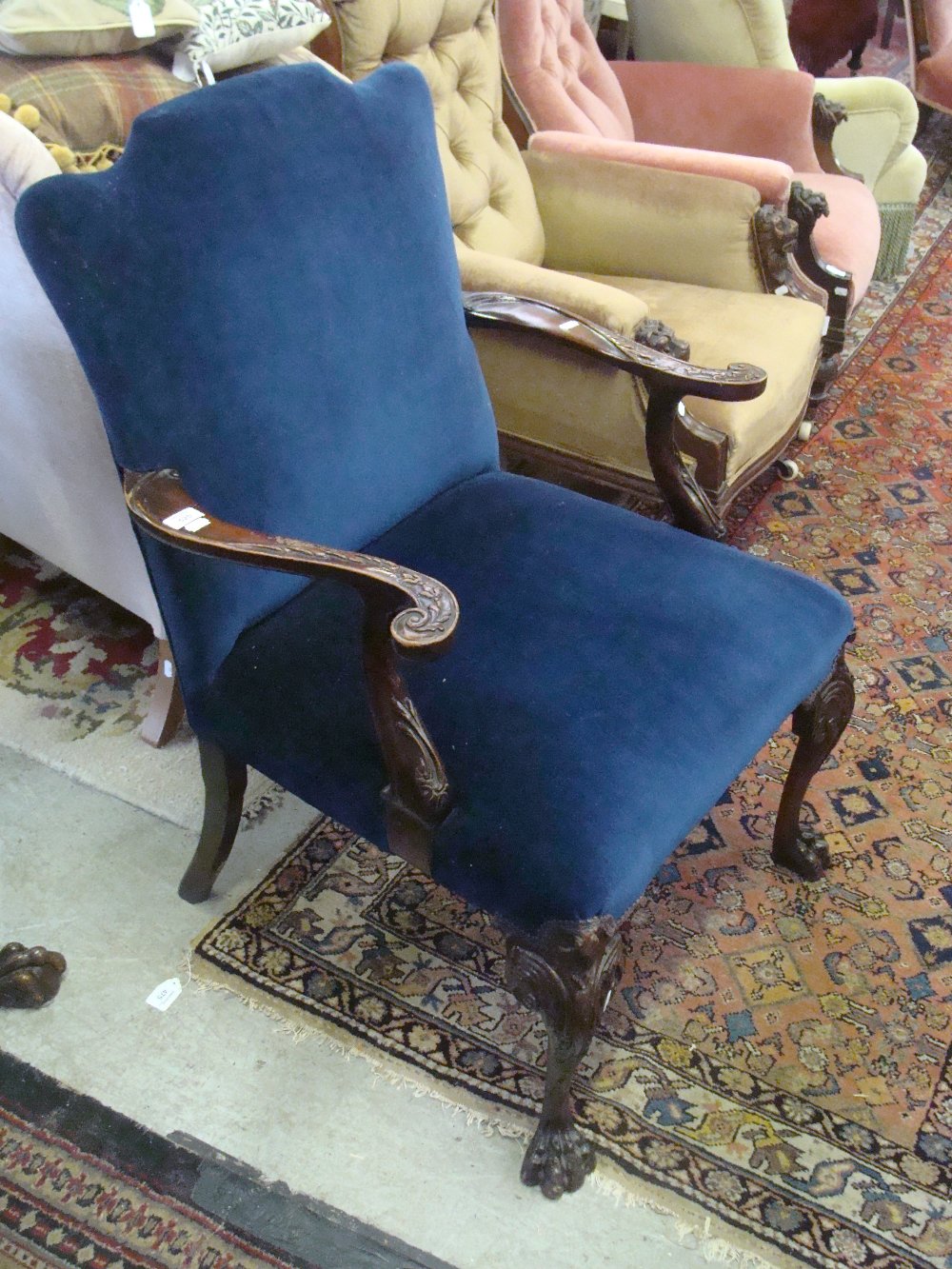 A Chippendale style walnut open armchair with carved cabriole legs, upholstered in blue velvet