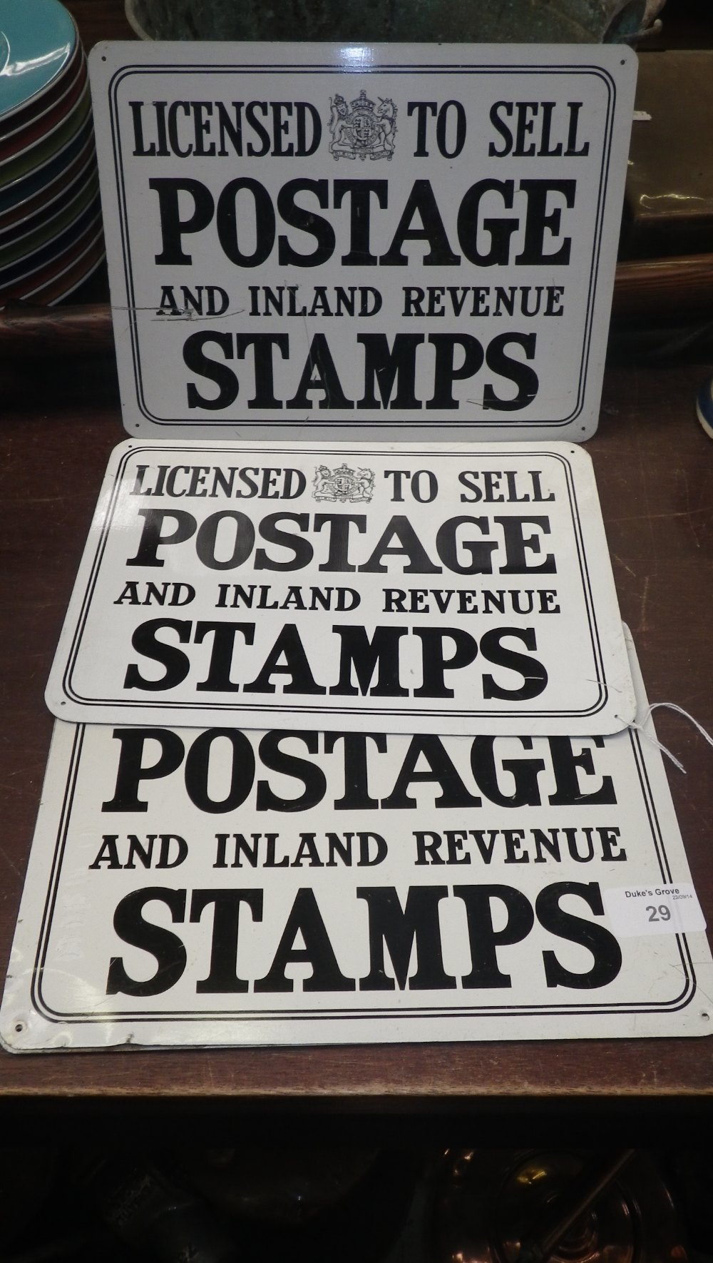 A collection of vintage signs `Licensed to Sell Postage and Inland Revenue Stamps` (acquired by the