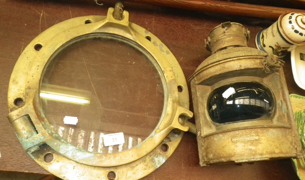 A polished bronze porthole and a ship`s `starboard` lamp