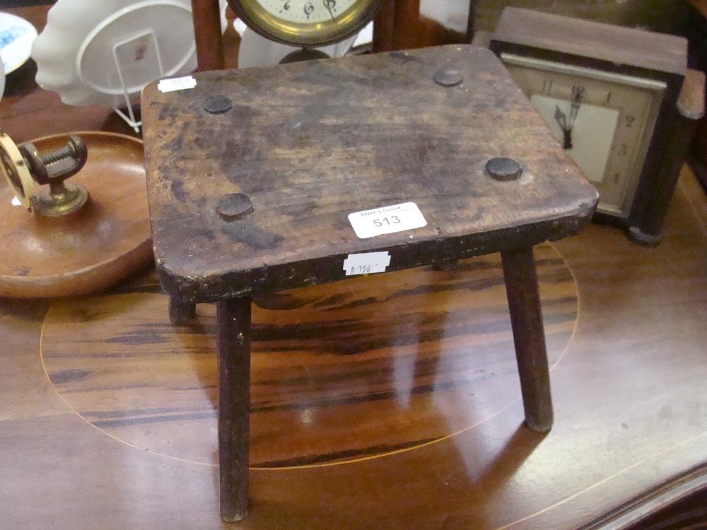 A naive milking stool on four legs