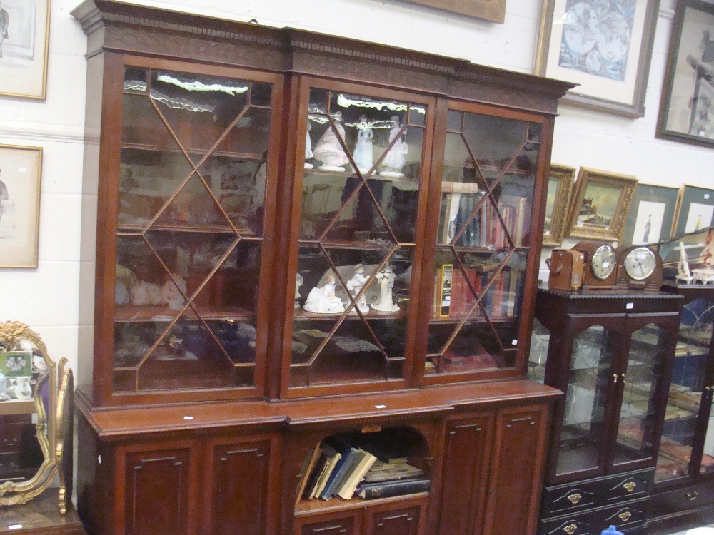 An early 20th century mahogany breakfront bookcase, the upper section with astragal glazed doors,