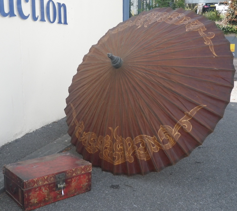 A Chinese red lacquered trunk and a large parasol