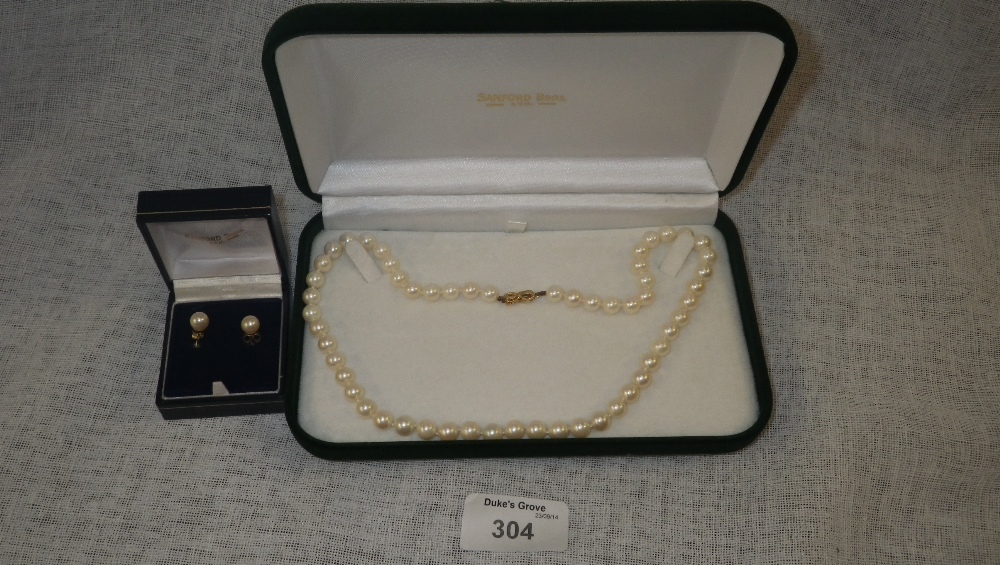 A pair of Sandford Bros. `pearl` stud earrings and a similar necklace