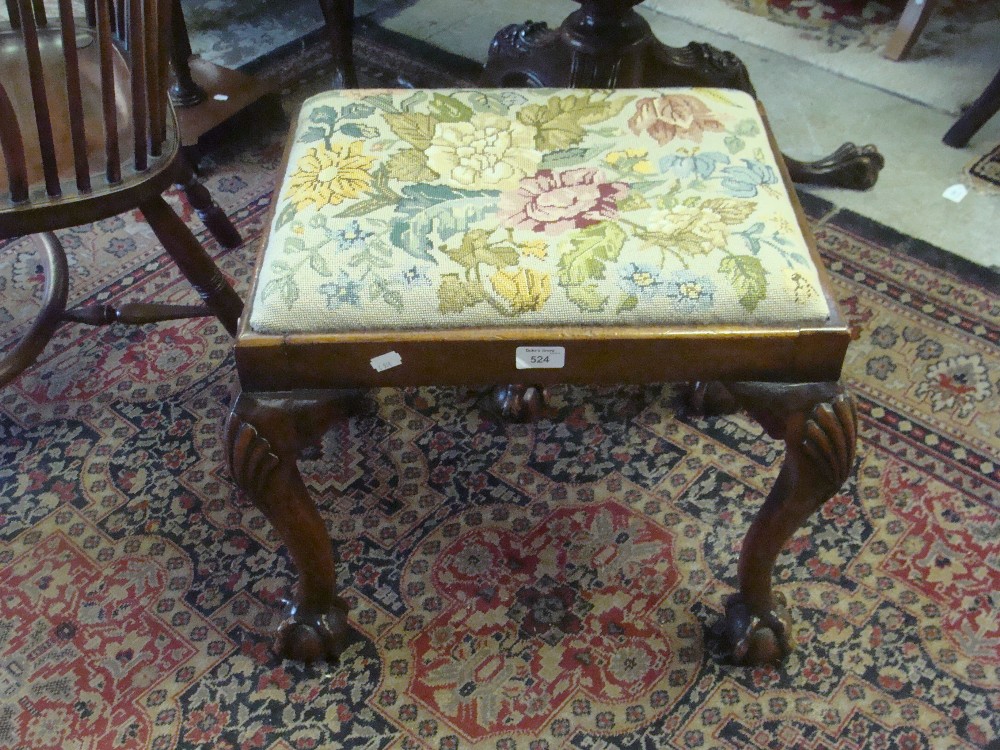 A walnut dressing stool with shell-carved cabriole legs and needlework seat