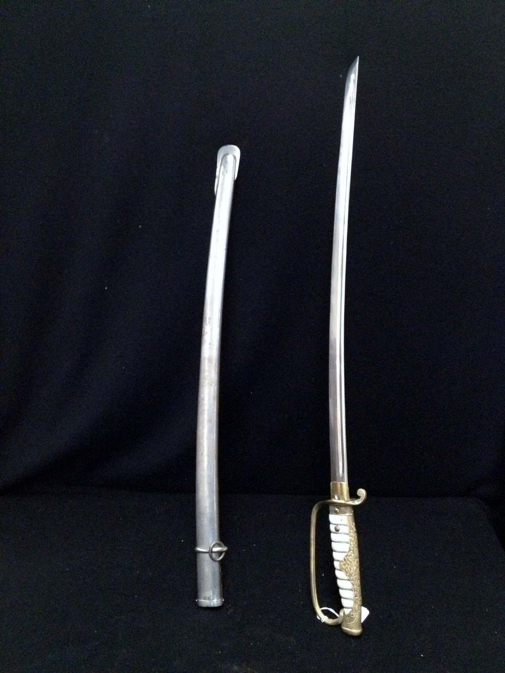 A sword with gilt foliate decorated handle and leather mounted grip in steel scabbard