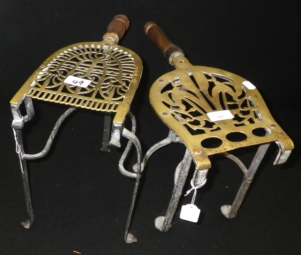 A brass and iron kettle stand, decorated with Prince of Wales Feathers, together with another