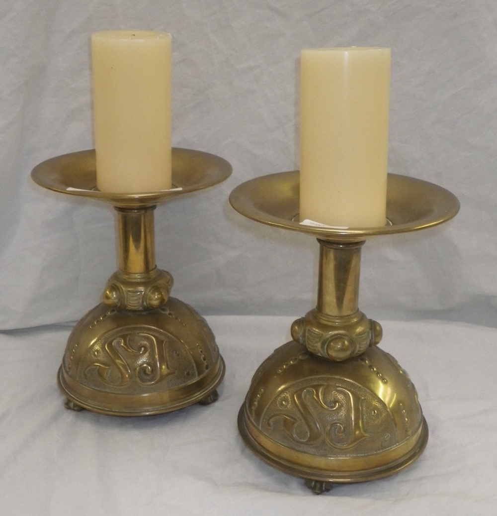 A pair of brass altar candlesticks in early Gothic Revival style, the dome-shaped bases with cipher