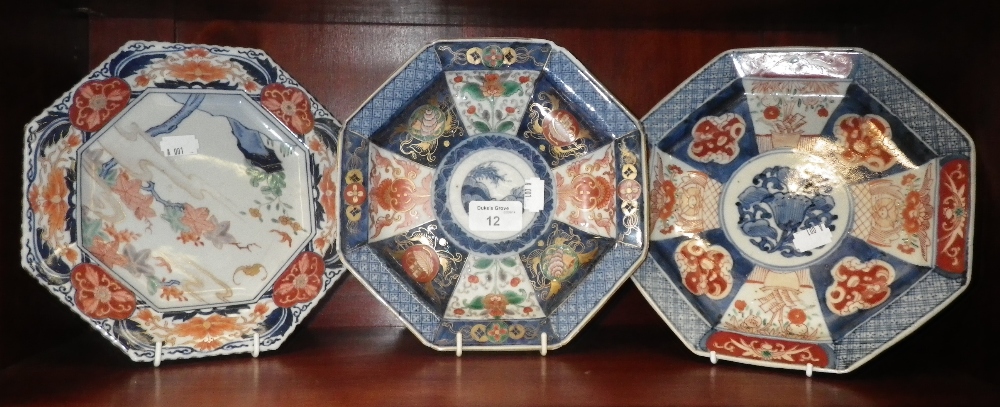 An octagonal plate decorated in the Imari manner and two others similar