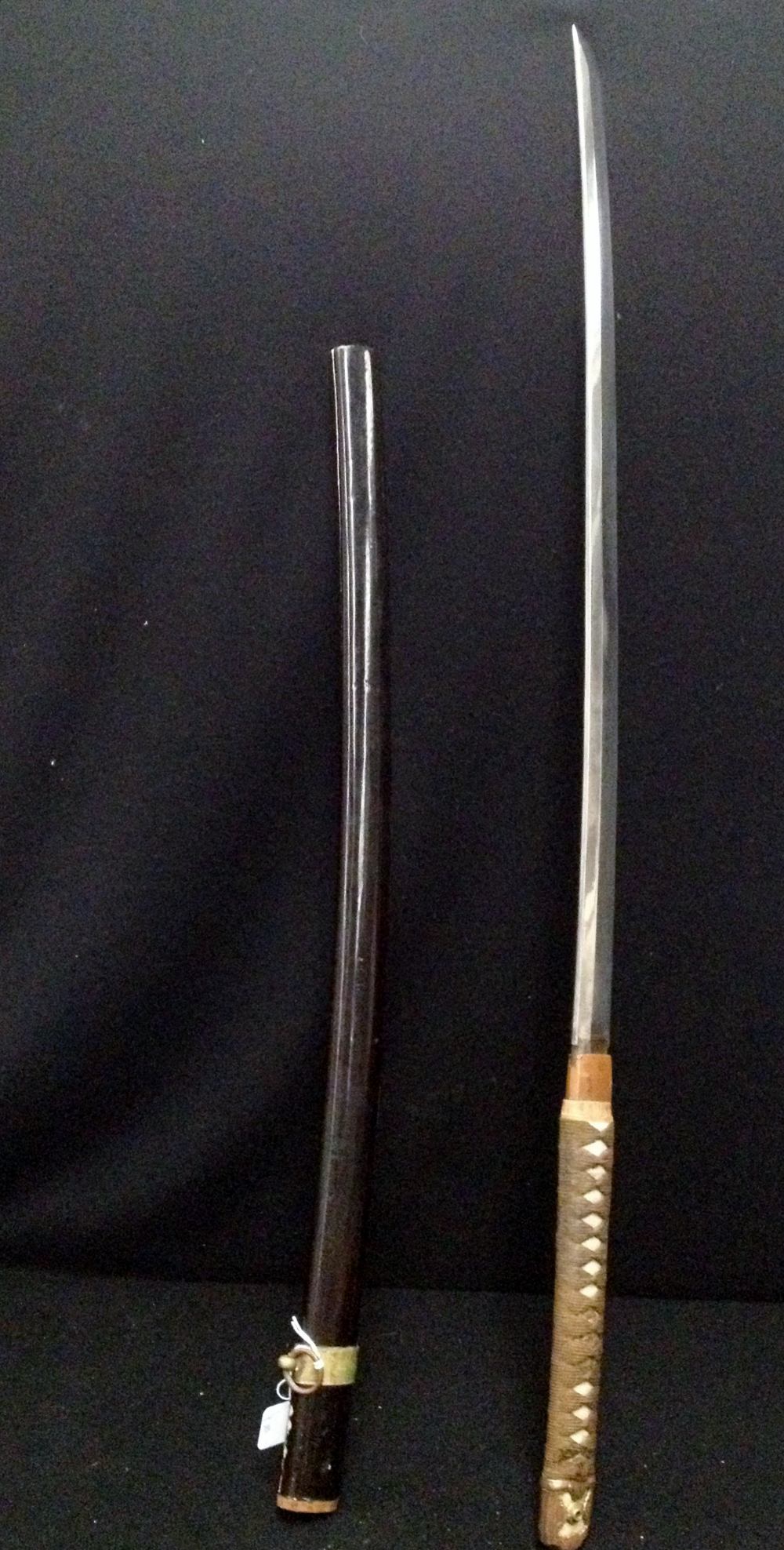 A Japanese sword with shagreen and silk wrapped handle and lacquered scabbard