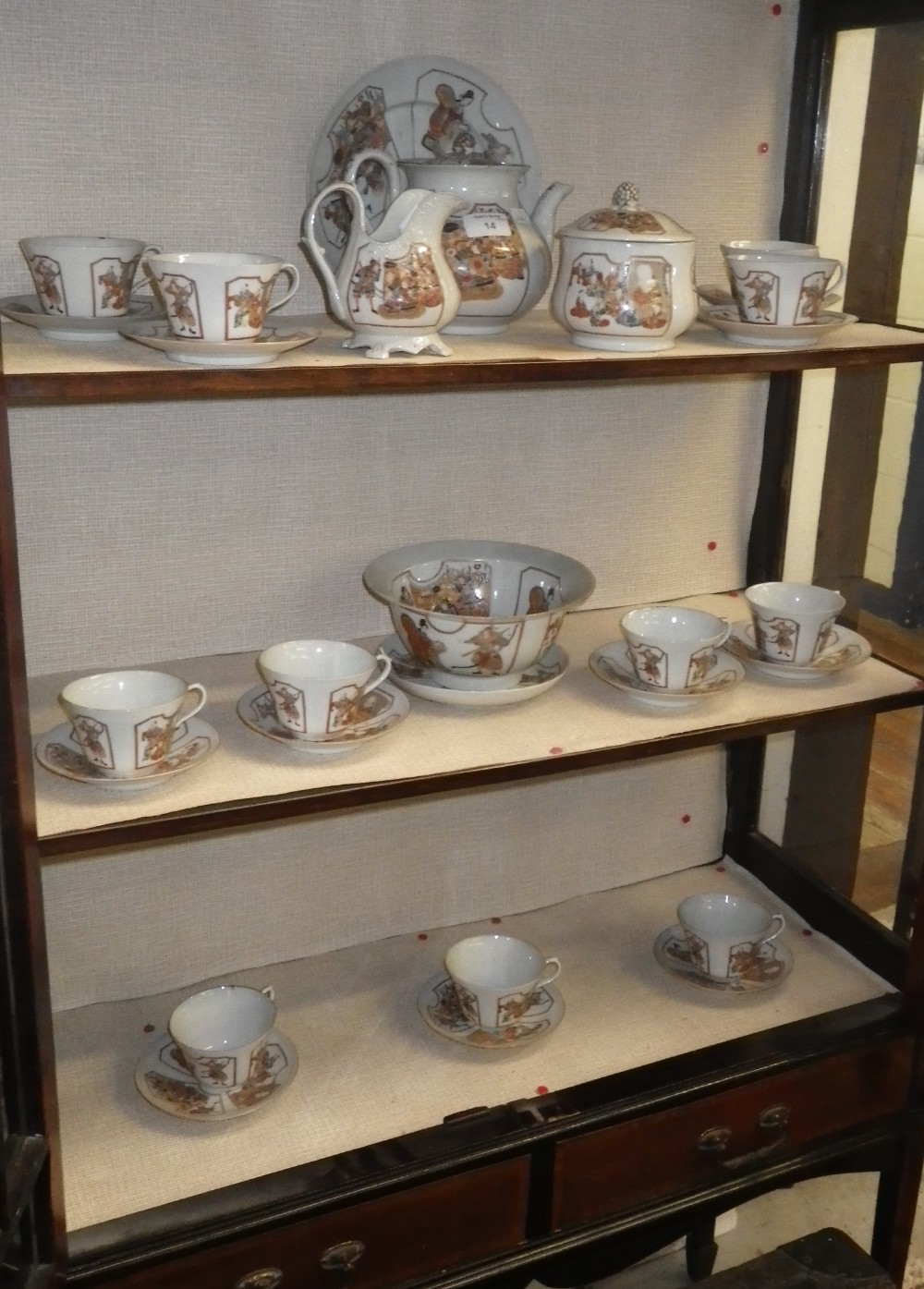 A Japanese Kutani style teaset, decorated with panels of figures on a white ground.