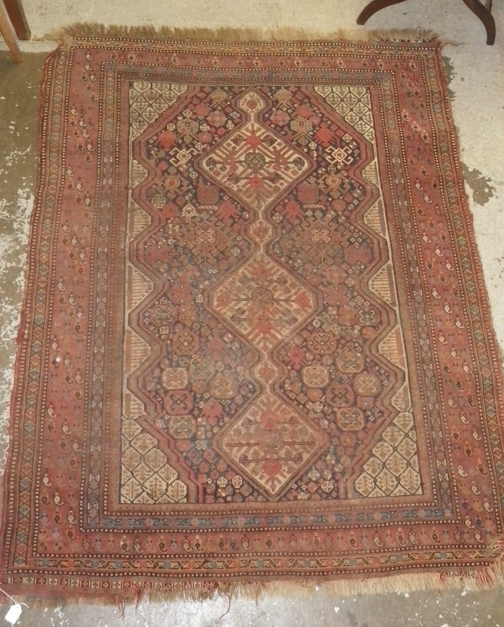 A russet ground Persian rug with stylised central panel with three central medallions, 68" x 52" (
