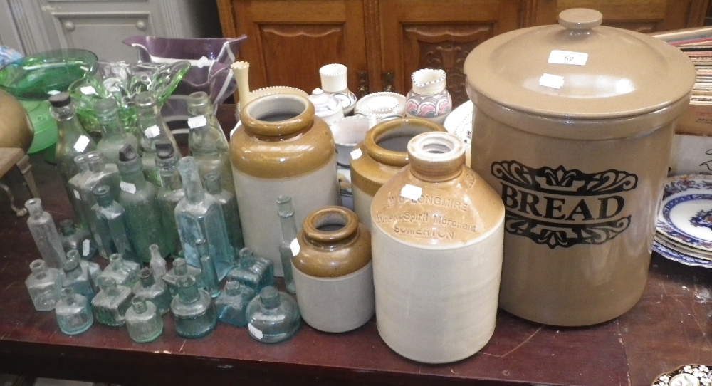 A stoneware flagon, stamped `W G Longmire, Somerton` and a collection of similar bottles and storage