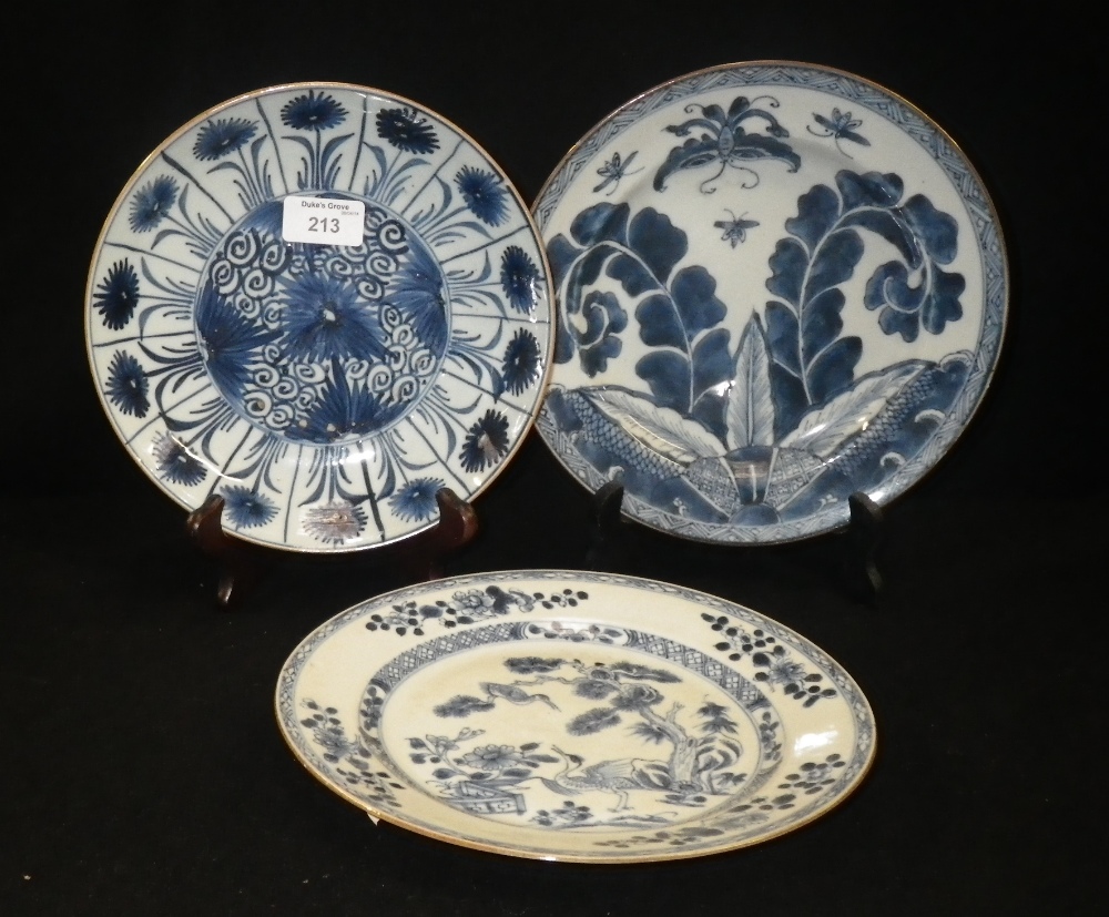 Three Chinese blue and white plates decorated with various floral patterns.