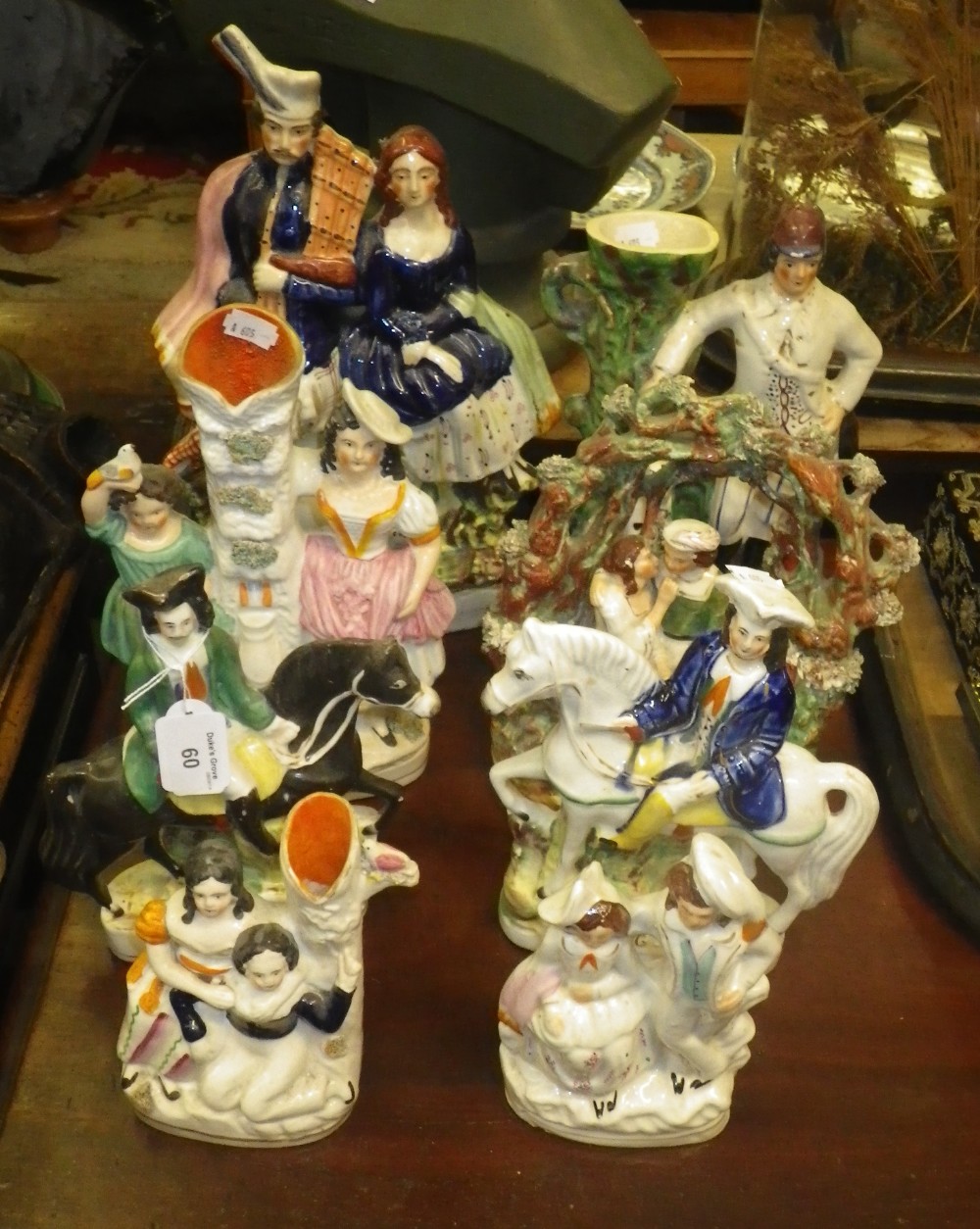 A Staffordshire spill vase in the form of a huntsman with his dog and a collection of similar