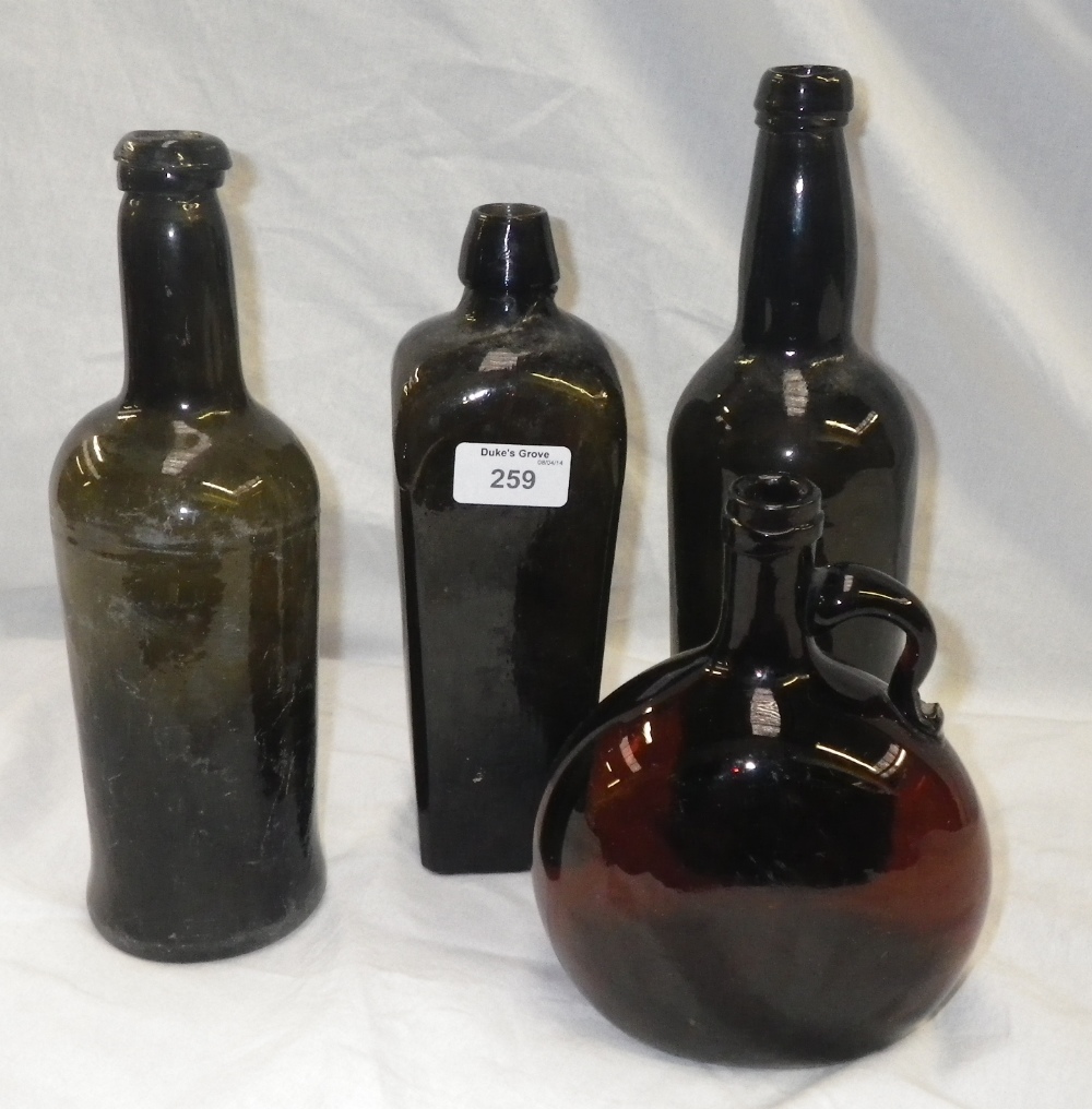 A vintage green glass bottle of square tapering form and three similar bottles.