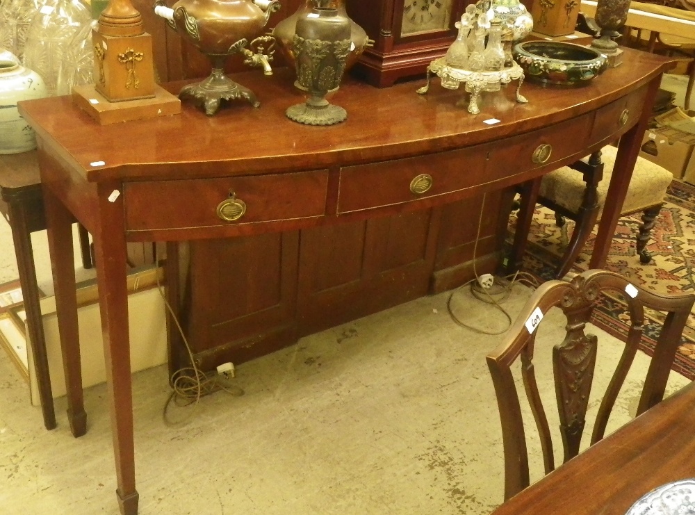 A George III bowfronted mahogany serving table, fitted three drawers on square tapering legs.