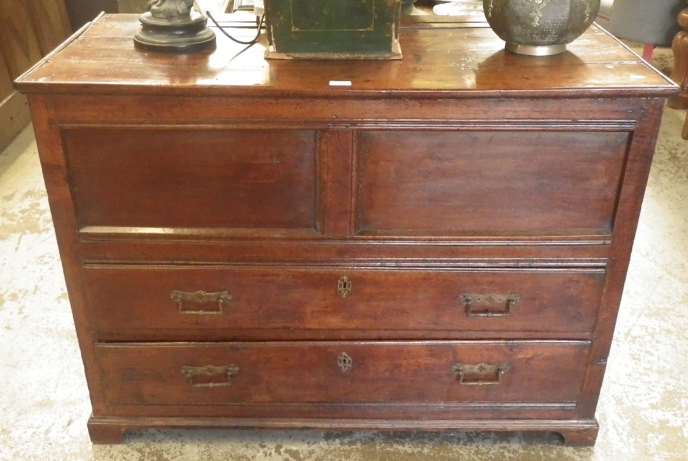 An early 18th century mule chest with a lift-up top, panelled front with two drawers below.