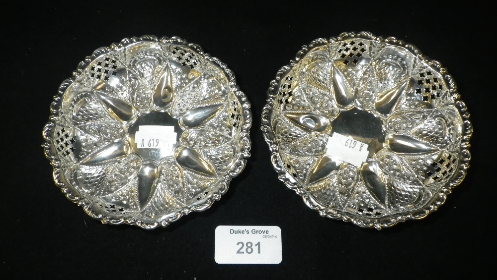 A pair of pierced and repoussé silver bon bon dishes with raised ball feet (2).