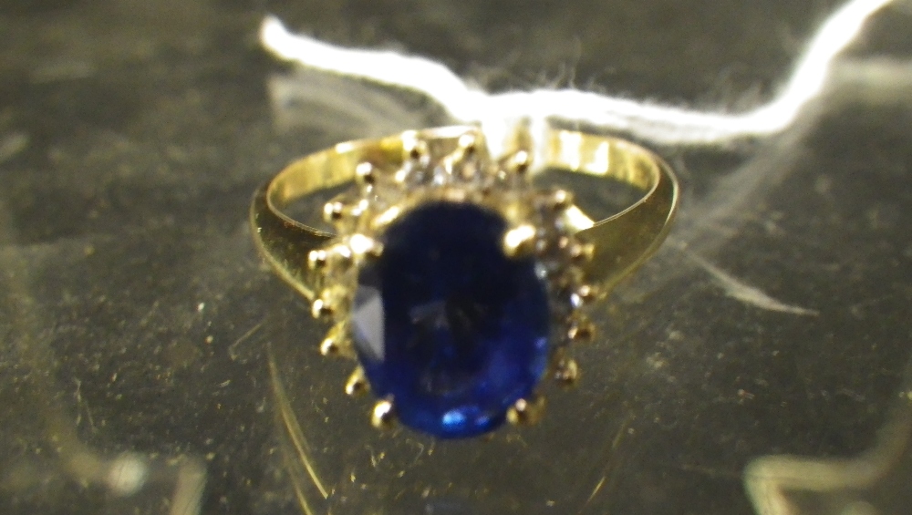 An oval sapphire and diamond cluster ring.