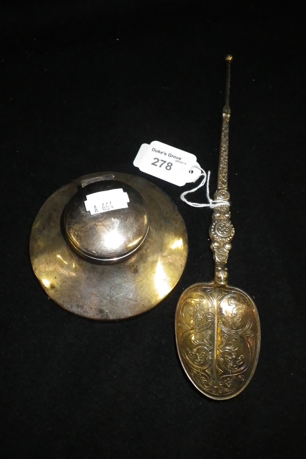 A circular silver Capstan inkwell and a silver gilt Celtic rat-tail bowl spoon (2).