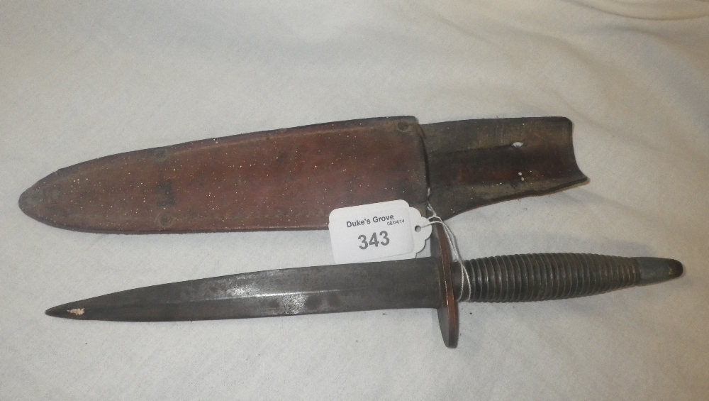 A dagger in leather scabbard, possibly a `Commando Dagger`.