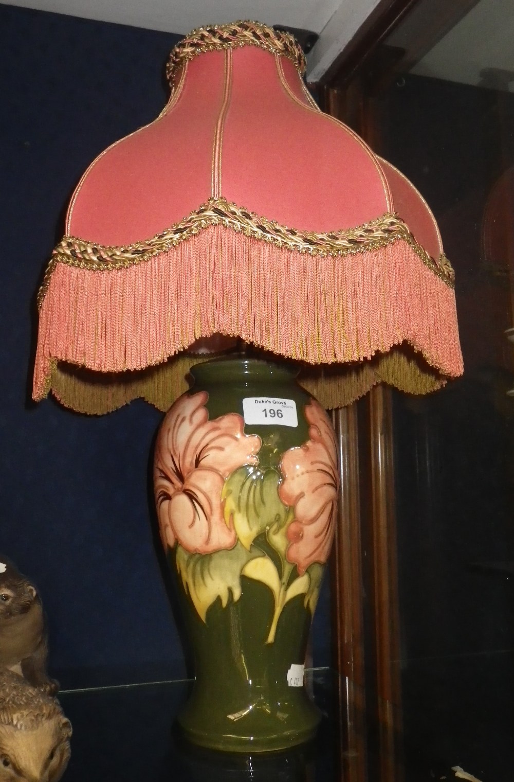 A Moorcroft pottery table lamp, the base of vase-shape form decorated with hibiscus against a