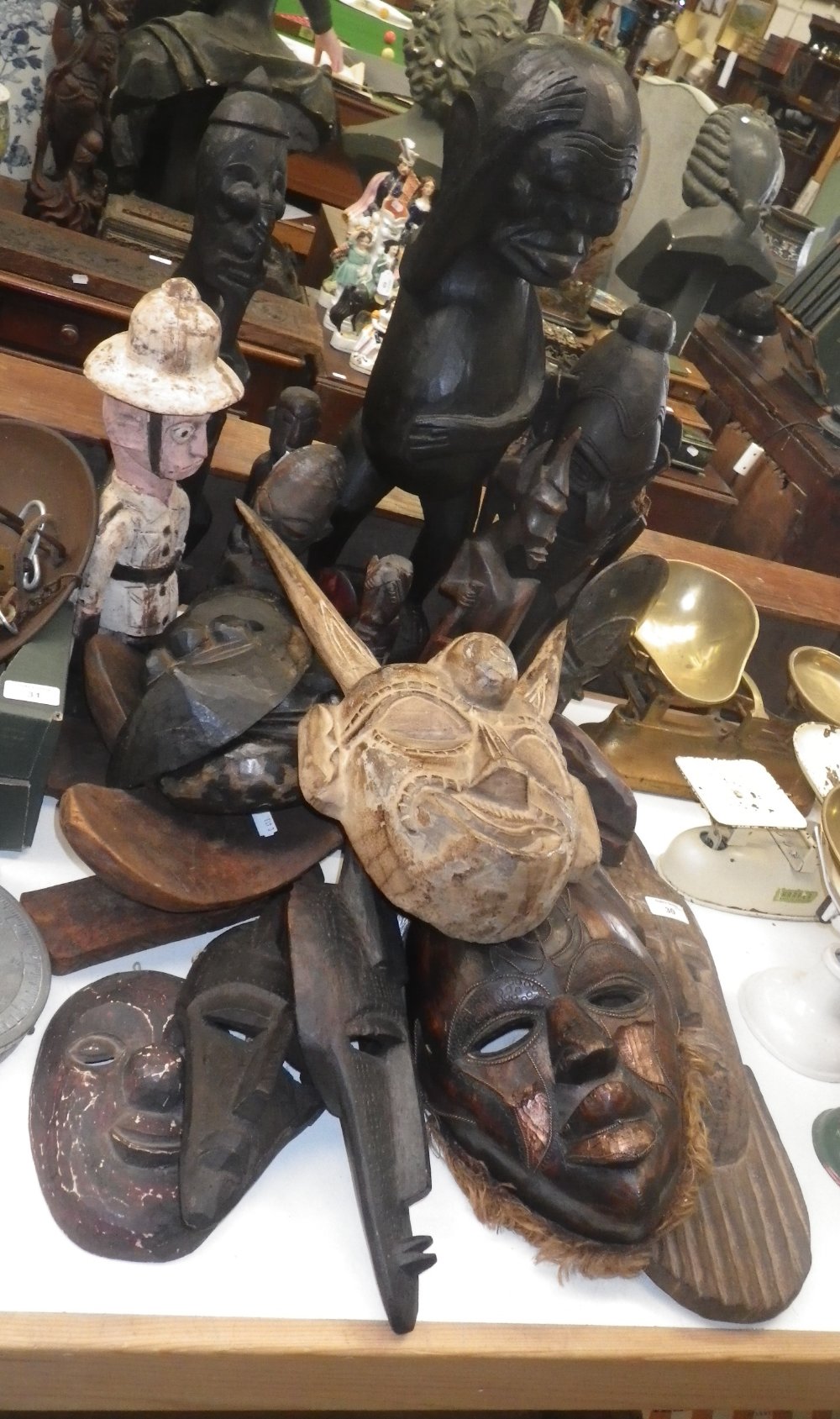 A collection of African carved wooden masks and similar tribal figures.