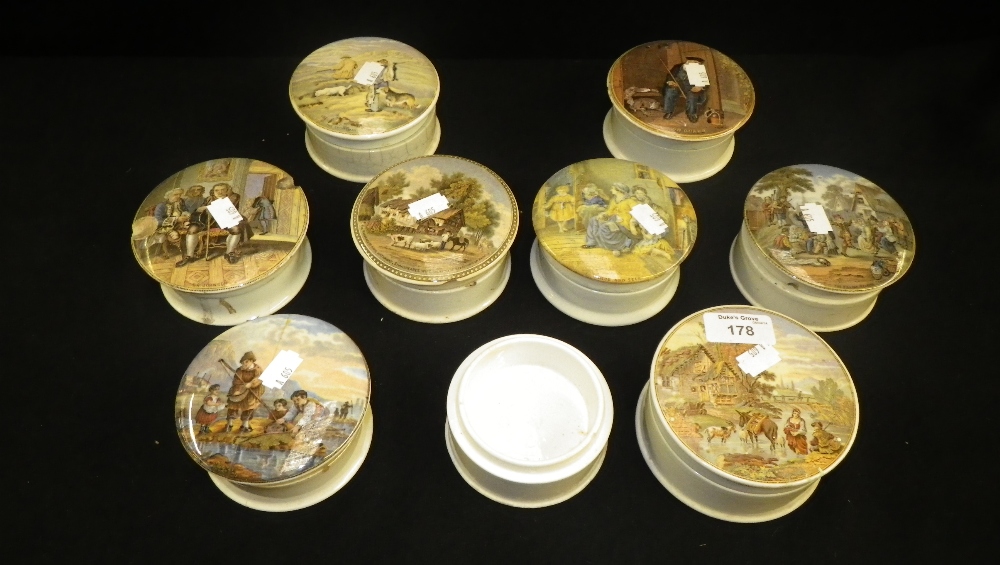 A collection of eight pot lids decorated with various scenes.