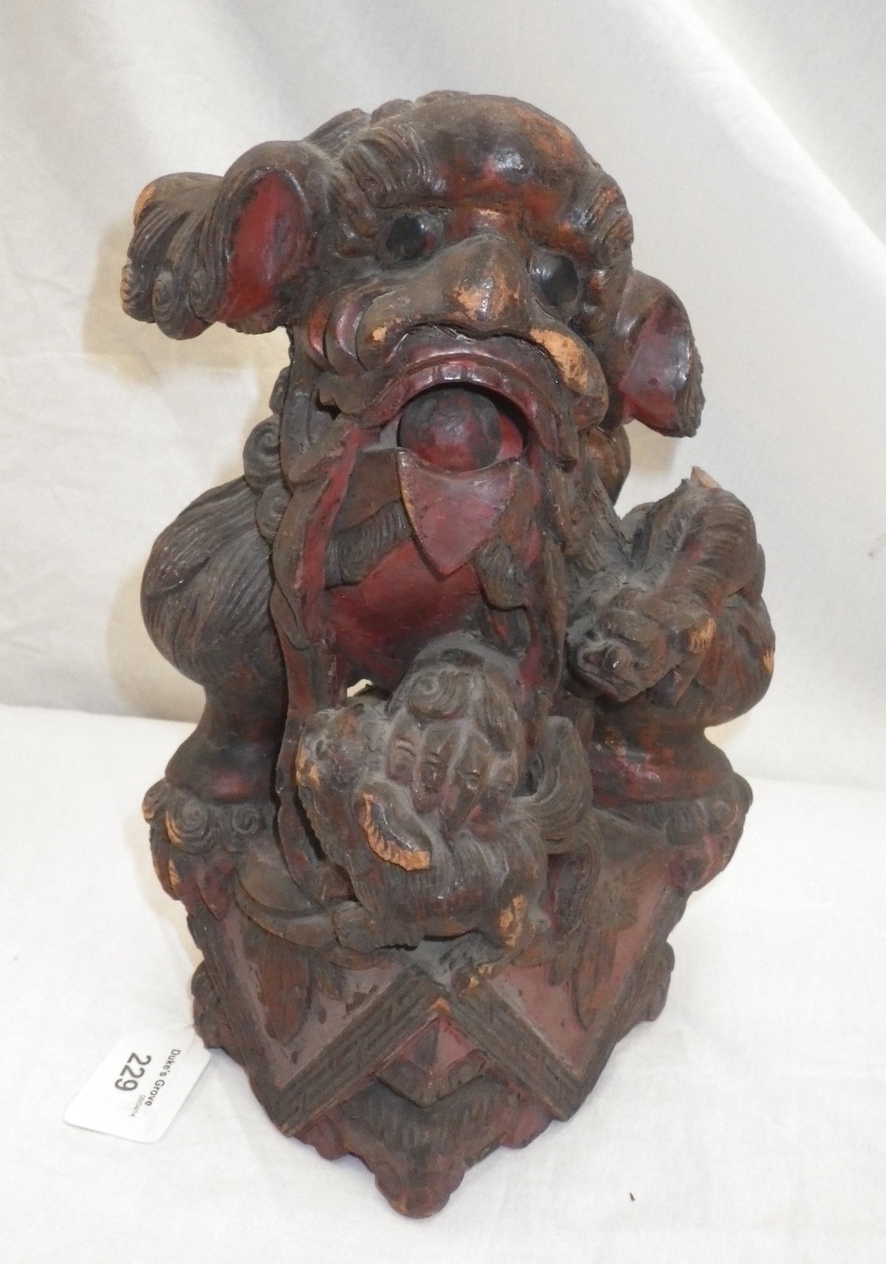 A Chinese carved wood figure of a guardian lion.