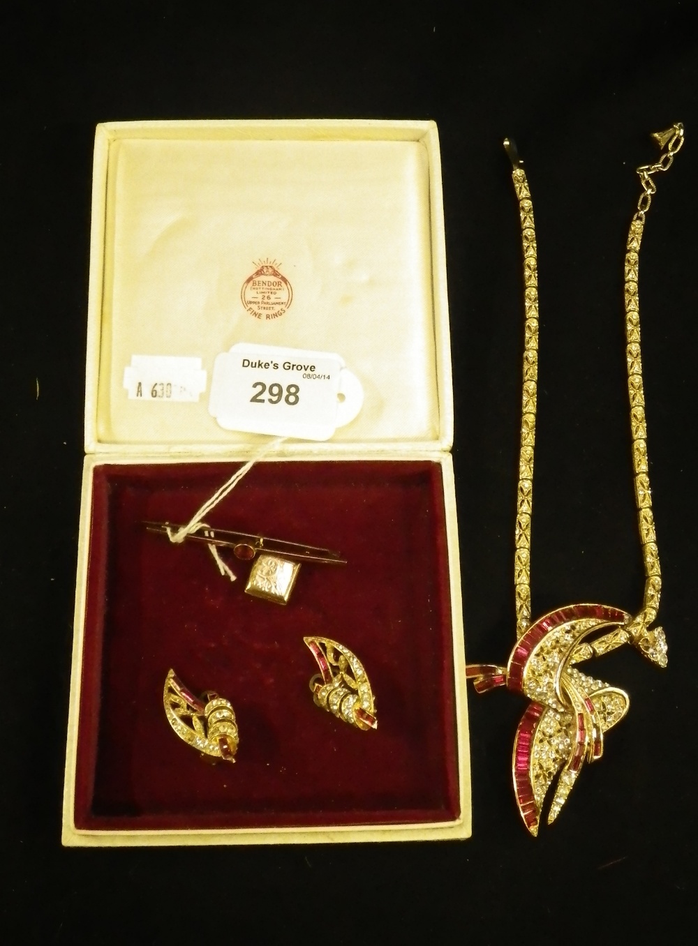 A clear and red paste gold coloured suite of jewellery including a necklace and a pair of