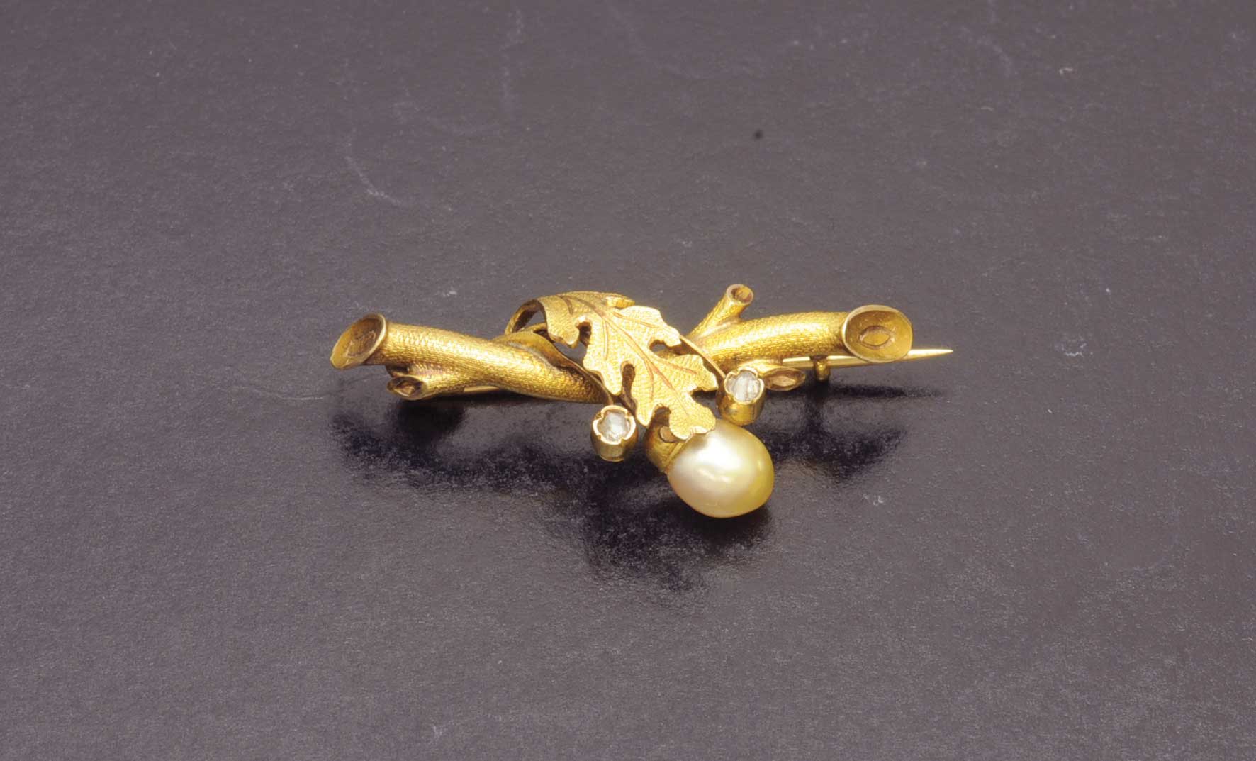 Broche de oro amarillo de 18 K. realizado en forma de rama con diamantes y perla oval.Starting