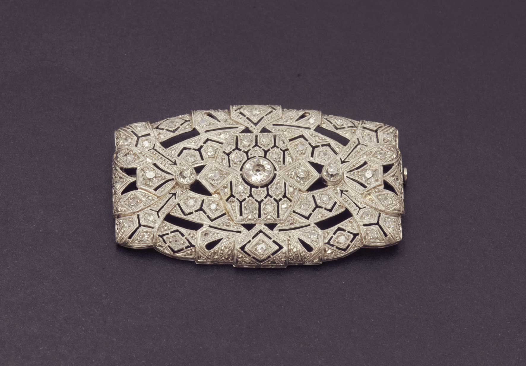 A platinum brooch with diamonds. Muy bella placa de platino con tres diamantes en chatón y diamantes