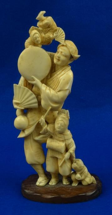 Oriental carved ivory figure group with monkey, the figures clutching musical instruments and a