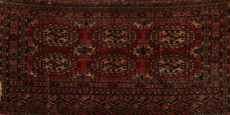 Middle Eastern rug decorated with geometric medallions onto a predominantly dark red ground, 137cm