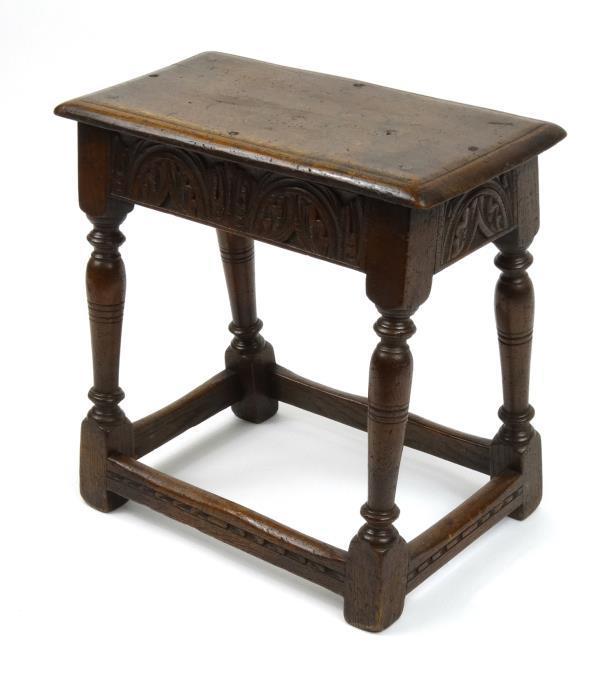 Rectangular oak joynt stool with carved freeze and baluster turned supports raised on square feet,