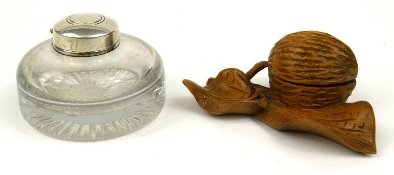 Circular glass inkwell with silver coloured metal lid stamped `Silver`, together with a carved wood