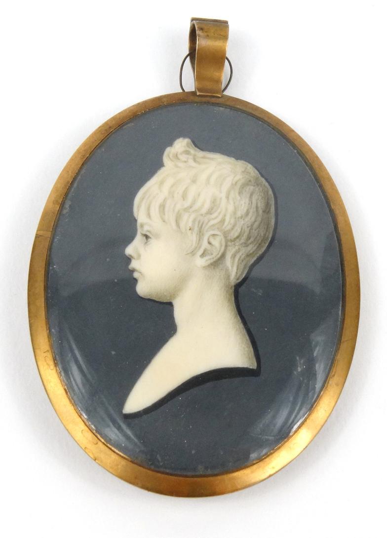 Oval portrait miniature mourning pendant with a view of a young child the reverse with foil back