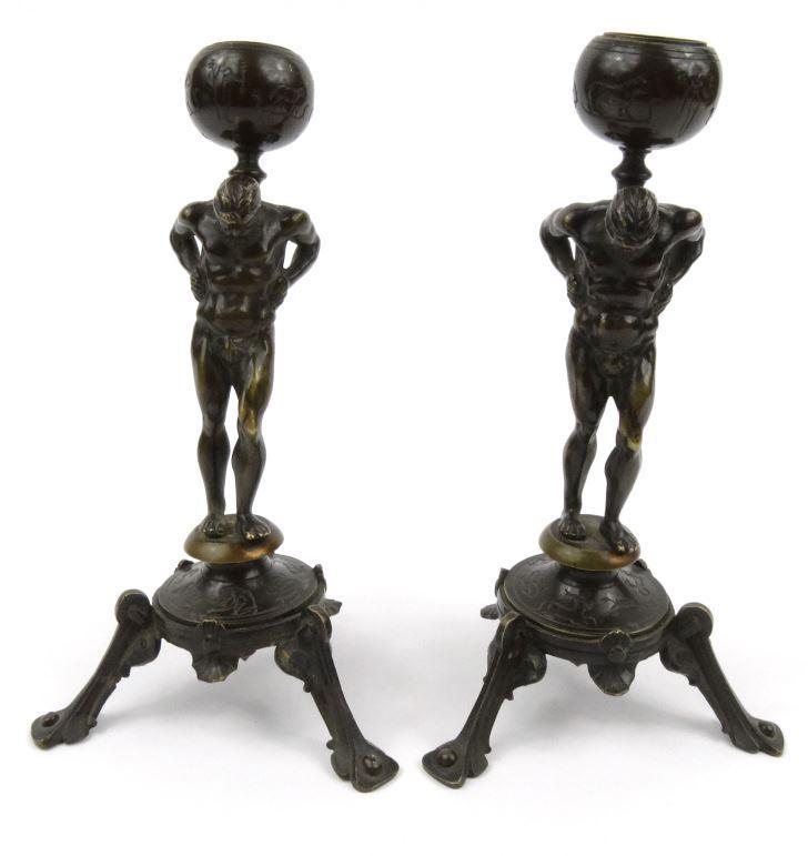 Pair of bronze Atlas design Zodiac candlesticks with shaped tripod feet  20cm high : FOR CONDITION