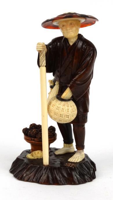 Oriental okimono modelled as a carved wood figure with ivory head, hands, feet, basket and objects,