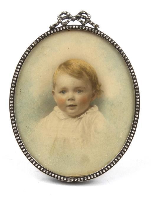 Oval portrait miniature of a young child housed in a cockbeaded and swag mounted metal frame, 8cm x