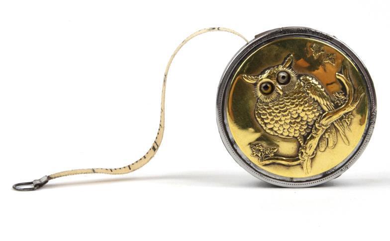 Novelty Edwardian metal bound tape measure decorated with a view of an owl set with glass eyes to