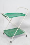 A 1970`s tubular metal and green plastic two tier serving trolley raised on the original castors.