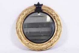 A large 19th century Regency circular mirror having swag detail to the gilded wooden frame with
