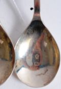 Two hallmarked silver spoons, each with mythological animals and shields to the top in enamel.
