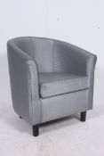 A 20th century contemporary tub armchair on black raised supports being upholstered in a modern
