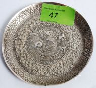 A fine Islamic / Iranian silver dish raised in relief with central peacock motif surrounded by