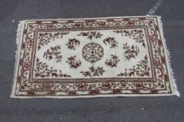 A 20th century English rug with scolled form being wool with deep pile. 170cms x 105cms