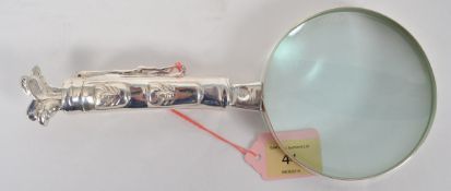 A decorative unusual magnifying glass with silver plate handle in the form of a golf bag with